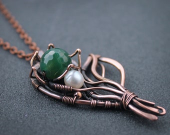 May include: A copper wire necklace with a green agate stone and white pearls. The wire is twisted and shaped into a leaf design.