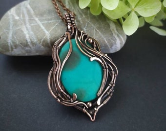 May include: A copper wire wrapped pendant featuring a turquoise green gemstone. The pendant is on a copper chain.