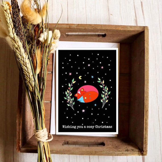 Wishing you a cosy Christmas. Cosy fox Christmas card. Sleeping fox with winter foliage and stars.