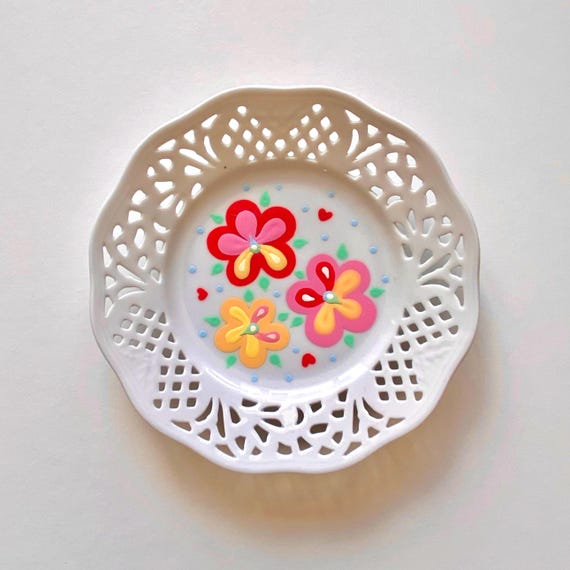 Small vintage plate with cut out details hand painted with flowers, leaves and dots. Decorative wall plate or trinket dish