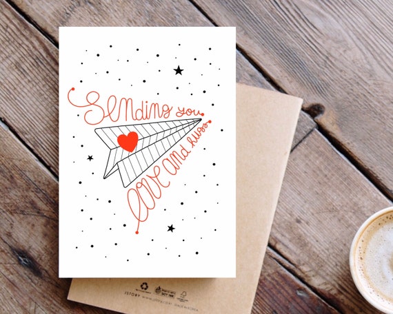 Sending You Love And Hugs. Paper plane and red heart A6 greeting card.