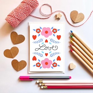Kaart met liefde, roze bloemen en blauwe bladeren. Love you-kaart, valentijnskaart, verlovings- of trouwkaart. A6-wenskaart.