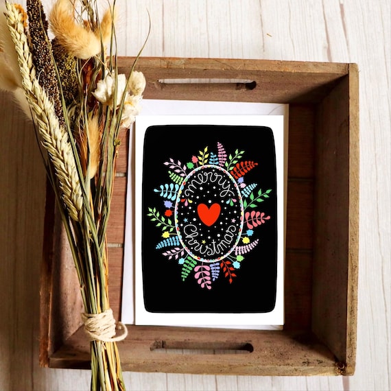 Rainbow Christmas wreath and heart on black card. Winter foliage wreath. Merry Christmas. Mistletoe and holly wreath.