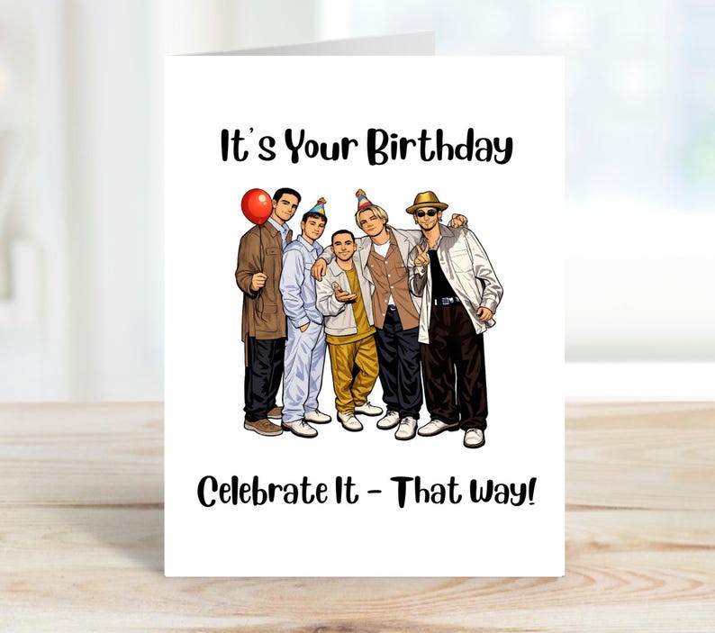 May include: A white greeting card with the text "It's Your Birthday" and "Celebrate It - That Way!" A cartoon illustration of six people in casual attire is featured on the card. One person holds a red balloon.