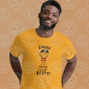 May include: A yellow t-shirt with a cartoon pirate character and the text "Cancer messed with the wrong booty!"