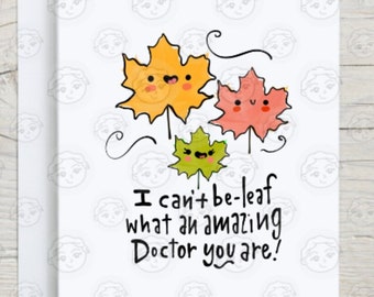 May include: A greeting card with an autumn theme featuring three cartoon leaves with smiling faces. The text on the card reads "I can't be-leaf what an amazing Doctor you are!"