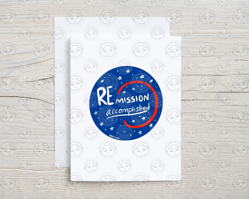 May include: A white greeting card with a blue circle that says "REMISSION accomplished" in white text. The card has a matching envelope and is decorated with a pattern of cartoon faces.