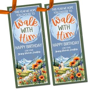 May include: Two bookmarks with the text "This year we hope you choose to walk with Him". The bookmarks have a blue background with a landscape scene of mountains, flowers, and figures. Orange ribbon is attached.