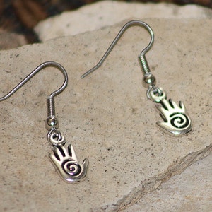May include: A pair of silver earrings featuring a hand design with a spiral detail.