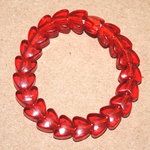 May include: A red heart-shaped bead bracelet. The bracelet is made of many small, red heart-shaped beads.