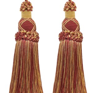 May include: Two decorative tassels featuring a blend of deep red and gold threads. Each tassel has a braided cord top, a wrapped gold neck, and a structured knot section above a long, flowing fringe made of mixed red and gold vertical strands.