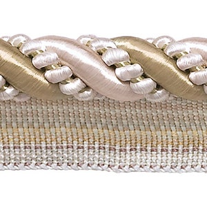 May include: A close-up of a braided trim with a pink and gold color scheme. The trim is made of a soft, woven fabric and has a delicate, elegant look.