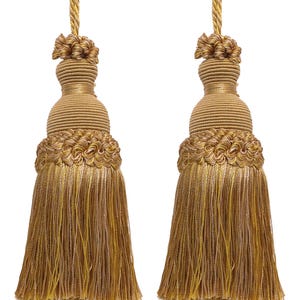 Peut inclure: Deux glands décoratifs dorés avec un dessus tressé et un bas à franges. Les glands sont faits d'un matériau jaune doré brillant avec un accent beige plus clair. Ils sont conçus pour la décoration intérieure.