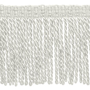 May include: Ivory-colored fringe trim with a woven top and twisted rope-like strands. This decorative trim is suitable for various craft and sewing projects, adding a textured element to designs.