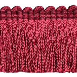 May include: Burgundy red fringe trim with a scalloped top edge. The fringe is approximately 1 inch in length.