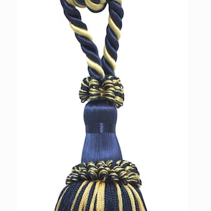 May include: A navy blue and gold tassel with a twisted rope design. The tassel is made of soft, silky fabric and has a long, flowing fringe.