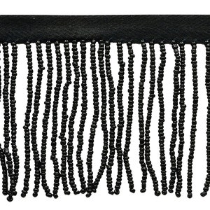 Puede incluir: Borde de flecos de cuentas negras. El fleco está hecho de pequeñas cuentas redondas que se ensartan para crear una línea continua de flecos. El fleco tiene aproximadamente 2,5 cm de largo.