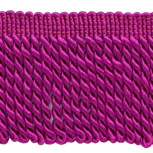 May include: A close-up of a deep magenta twisted fringe trim. The fringe is made of a soft, silky fabric and has a subtle sheen.
