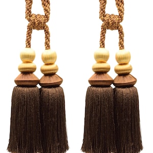 Peut inclure: Deux attaches de rideaux en forme de pompons marrons avec des accents dorés et marrons. Les pompons sont faits d'un matériau doux et moelleux et sont parfaits pour ajouter une touche d'élégance à n'importe quelle pièce.