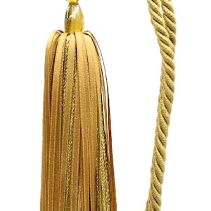 May include: A gold tassel with a long, twisted rope cord. The tassel is made of multiple strands of fabric and has a cluster of amber-colored beads at the top.