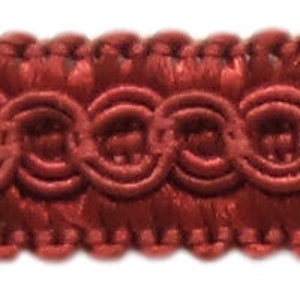 May include: Red braided trim with a repeating pattern of small circles. This trim is perfect for adding a touch of elegance to any project.