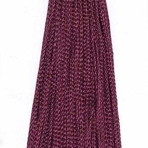 May include: A deep burgundy tassel with a knotted top. The tassel is made of a soft, silky material and has a long, flowing fringe.