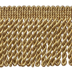 May include: Gold twisted fringe trim with a woven texture. This trim is ideal for adding a touch of elegance to any project.