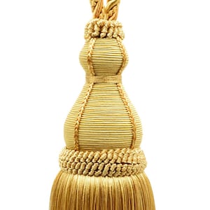 May include: A gold tassel with a braided cord and a fringed bottom. The tassel is made of a soft, luxurious fabric.