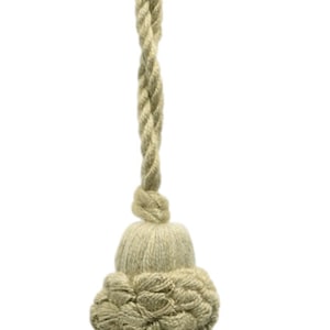 Op de afbeelding: Een beige kwast met een geknoopte bovenkant en een lang, gedraaid koord.