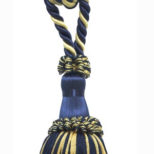 May include: A navy blue and gold tassel with a twisted rope design. The tassel is made of soft, silky fabric and has a long, flowing fringe.