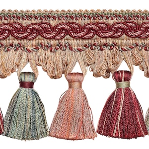 May include: A close-up of a decorative trim with a woven design and tassels. The tassels are in shades of red, green, and orange.