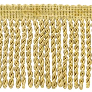 May include: A close-up of a gold twisted fringe trim. The fringe is made of a soft, woven fabric and has a subtle sheen.