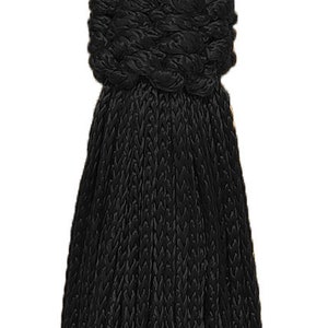 May include: A black tassel with a knotted top and a long, fringed bottom. The tassel is made of a soft, woven material.