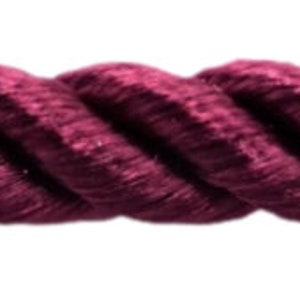 May include: Close-up of a length of burgundy-colored twisted rope. The rope is thick and has a textured appearance, with visible strands. The background is plain white.