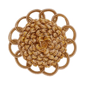 Peut inclure: Un bouton décoratif de couleur dorée avec un centre surélevé et texturé et un design circulaire ajouré autour du bord.