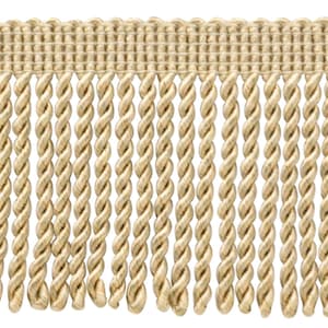 May include: A close-up of a beige twisted fringe trim. The fringe is made of a soft, woven fabric and has a subtle sheen.
