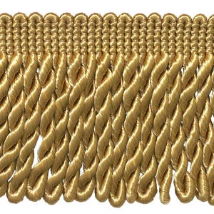 May include: A gold-colored bullion fringe trim featuring a woven header band with a series of thick, twisted rope-like strands hanging vertically. The trim has a consistent metallic sheen and a uniform, repeating pattern throughout the entire length.