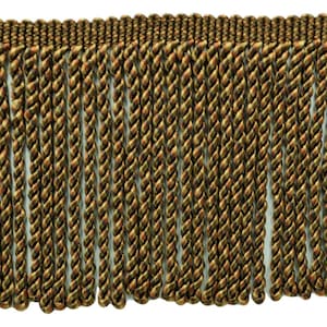 May include: A close-up of a brown, green, and orange twisted fringe trim. The fringe is made of a soft, silky material and has a subtle sheen.