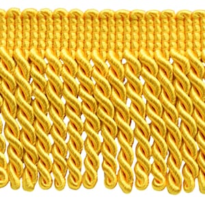 May include: A bright yellow decorative fringe trim featuring a horizontal woven header band with a series of uniform, twisted cord tassels hanging vertically from the bottom edge, creating a consistent and repeating textured pattern.