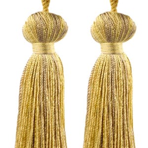 Può includere: Due nappe decorative nei toni dell'oro e del marrone. Ogni nappa presenta una parte superiore bulbosa con un anello di corda ritorta e una lunga frangia fluida. Queste nappe sono adatte per l'arredamento della casa o progetti artigianali.