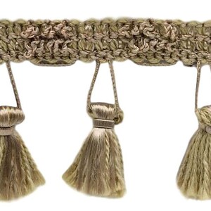 May include: A beige tassel trim with a woven design and fringe. The trim has a series of tassels that hang down from the woven band.