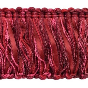 May include: Red and pink fringe trim with a woven texture. The fringe is approximately 1 inch in length.