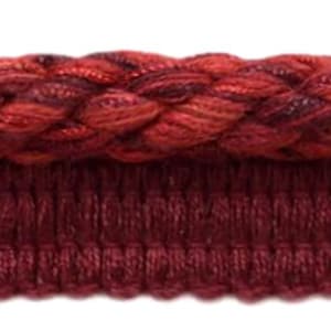May include: Red and burgundy braided trim with a textured woven design. The trim has a double layer with a smooth, woven bottom layer.