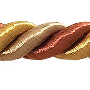 May include: A close-up of a braided trim featuring three colours: gold, brown, and red. The trim is made from a soft, woven fabric and has a subtle sheen.