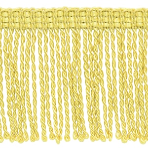 May include: A yellow twisted fringe trim with a woven top edge. This trim is perfect for adding a touch of elegance to any project.