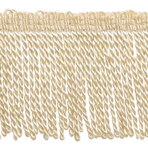 May include: A close-up of a beige twisted fringe trim. The fringe is made of a soft, silky material and has a subtle sheen.