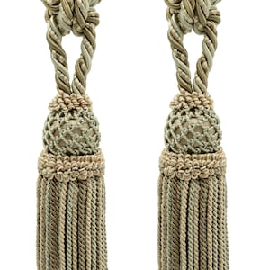 Op de afbeelding: Twee groene en beige kwastgordijnbandjes met een geknoopt touwontwerp en een decoratieve bal aan de onderkant.