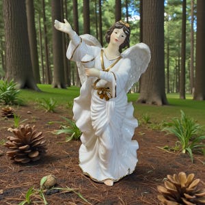 May include: A white ceramic angel figurine with gold trim and wings, holding a chalice. The angel has brown hair and is standing outdoors. The figurine is approximately 12 inches tall.