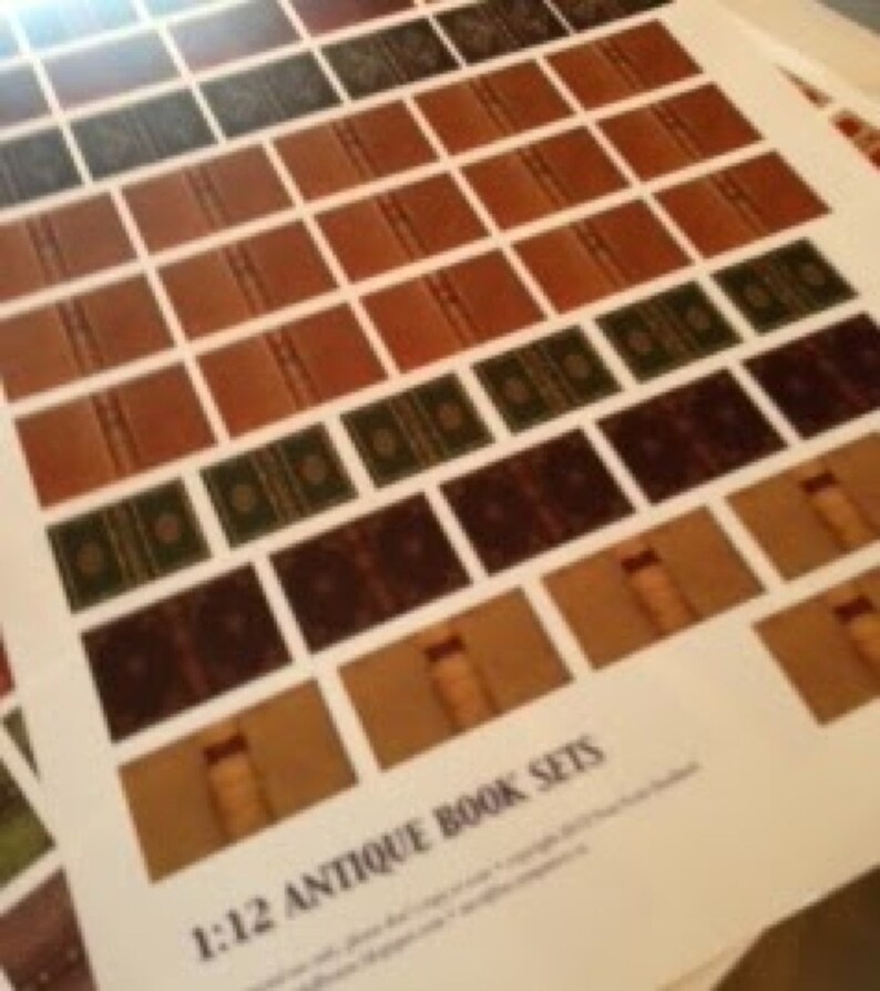 May include: A sheet of paper printed with multiple miniature antique book sets. The books are in various colors, including brown, green, and dark brown. The text "1:12 Antique Book Sets" is printed at the bottom of the page.