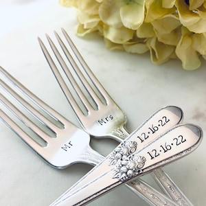 May include: Two silver forks with engraved text. The forks are engraved with "Mr" and "Mrs" and the date "12-16-22".